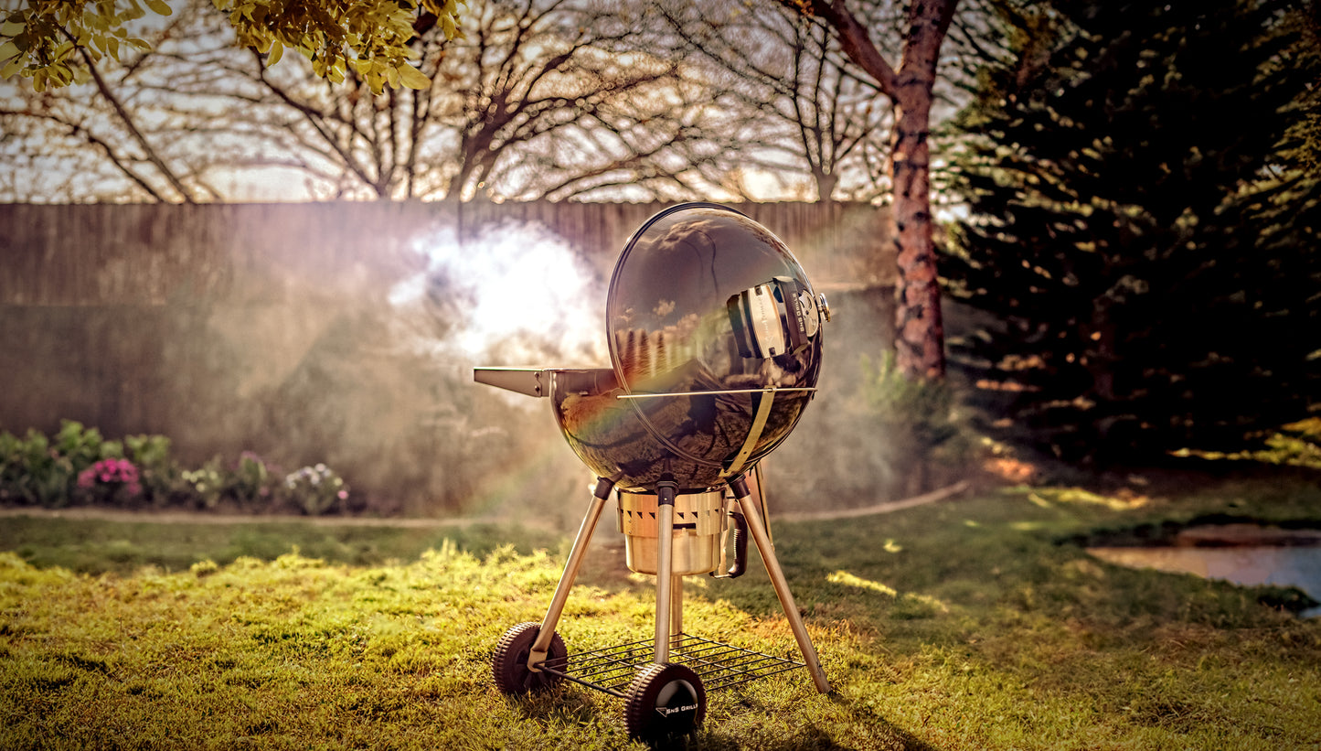 sns grill original charcoal kettle in backyard with smoke billowing out of grill